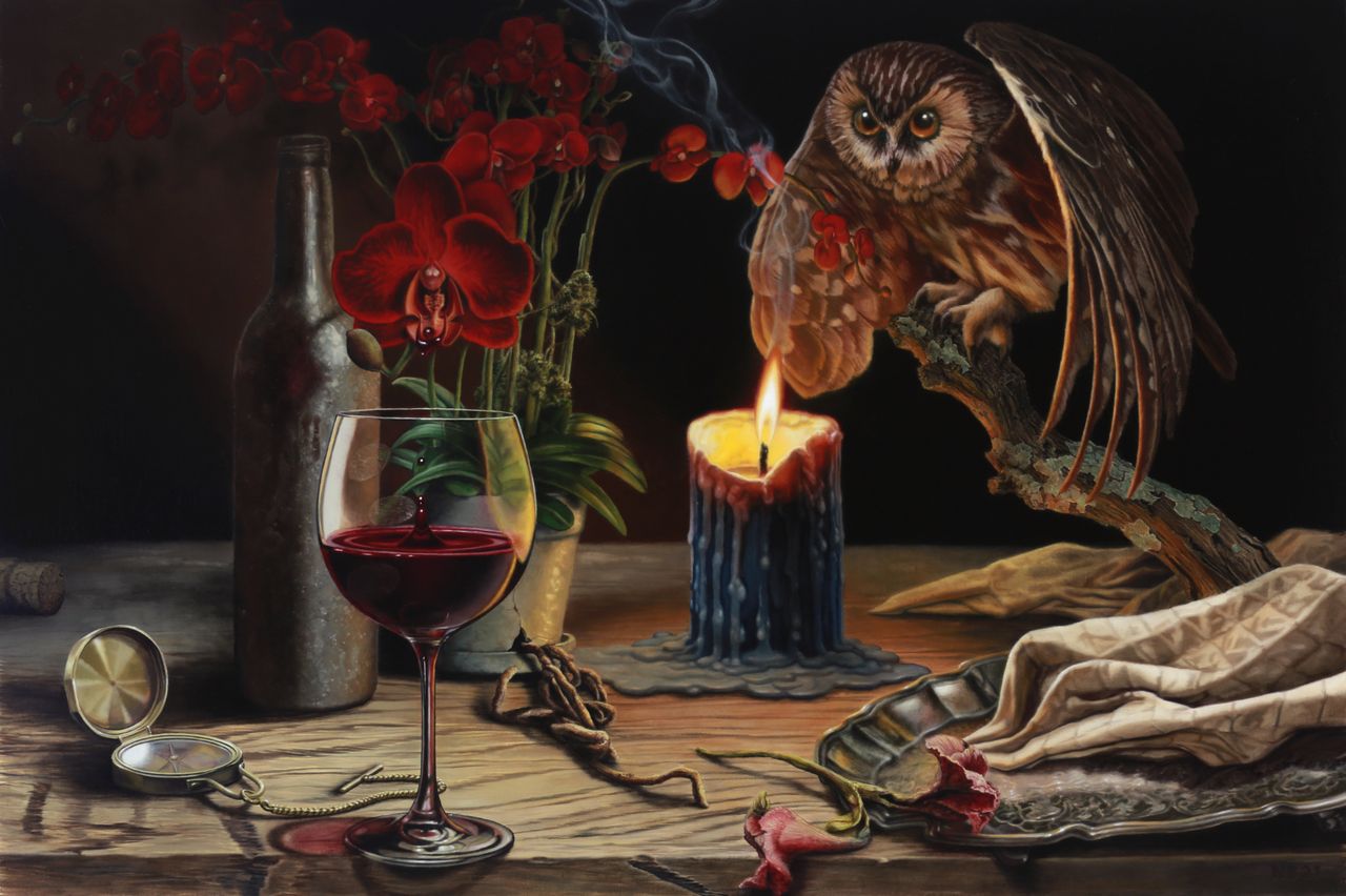 A brown owl perches beside a burning blue candle, red orchids, wine glass, bottle, open compass, scattered flowers, and draped cloth.