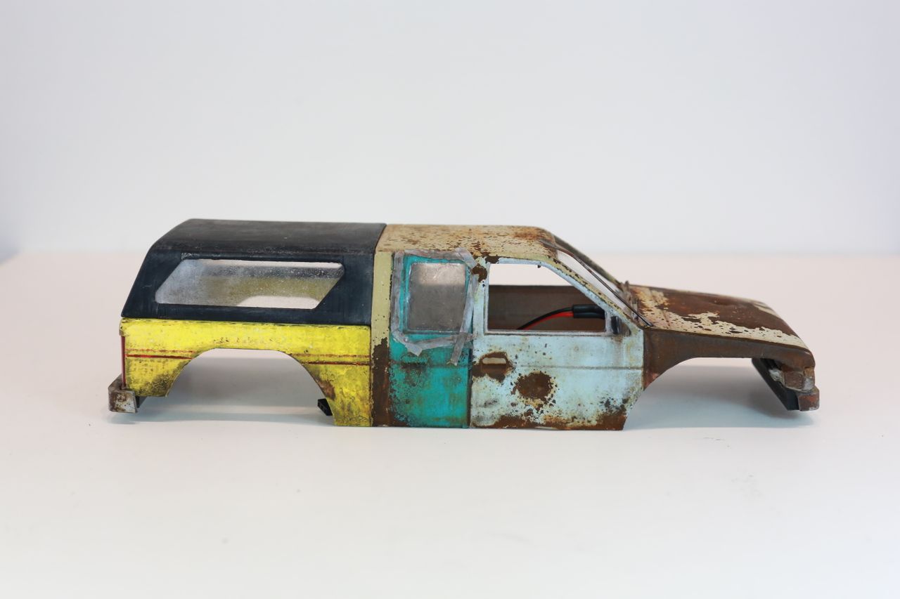 Old junkyard Nissan 1/24 scale 3d printed pickup body for scx24 RC truck with real rust patina, dents, duct tape windows, and custom bumpers.